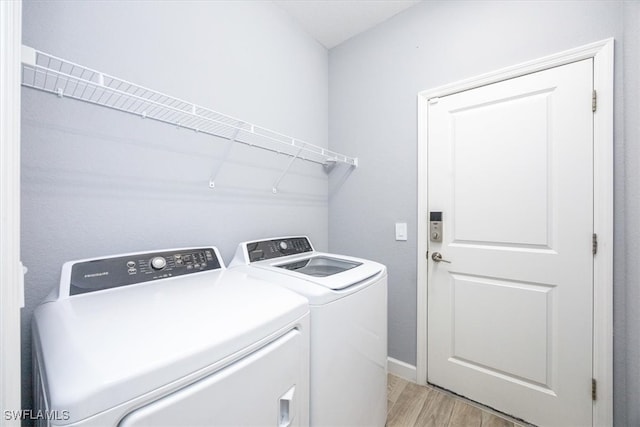 laundry room featuring washer and dryer and light wood-type flooring