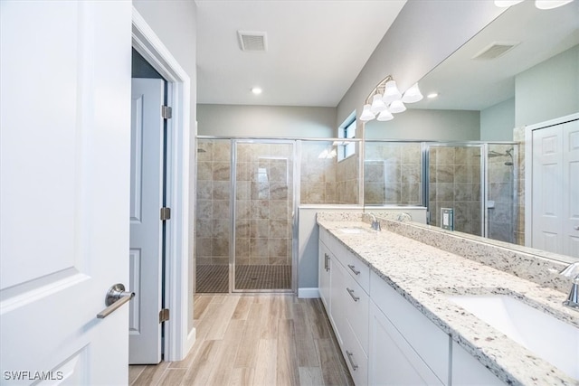 bathroom with vanity, wood-type flooring, and walk in shower