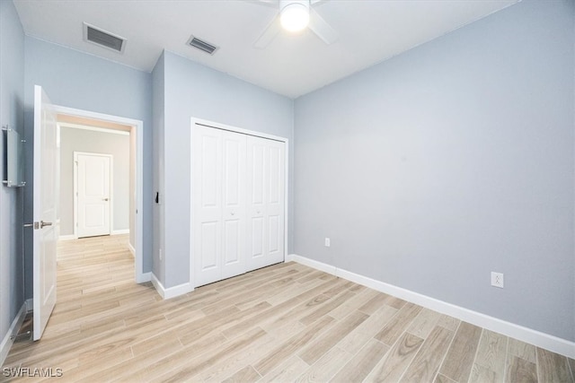 unfurnished bedroom featuring a closet, light wood-type flooring, and ceiling fan