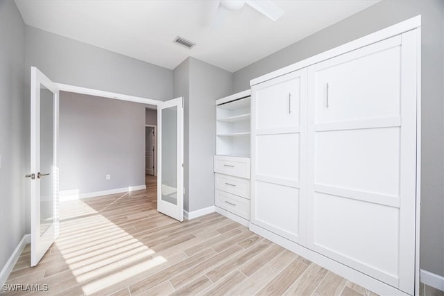 unfurnished bedroom with light hardwood / wood-style floors, a closet, and ceiling fan