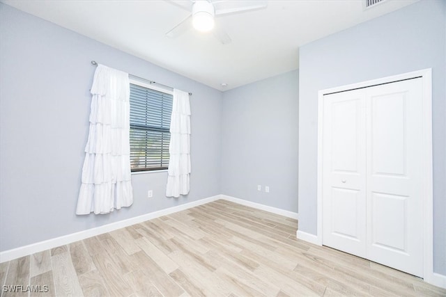 unfurnished bedroom with light hardwood / wood-style floors, a closet, and ceiling fan