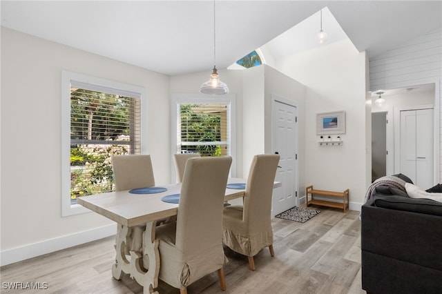 dining area with vaulted ceiling and light hardwood / wood-style flooring