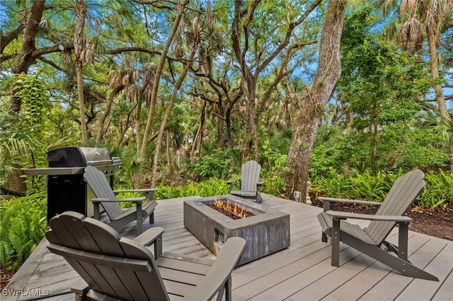 deck with a grill and a fire pit