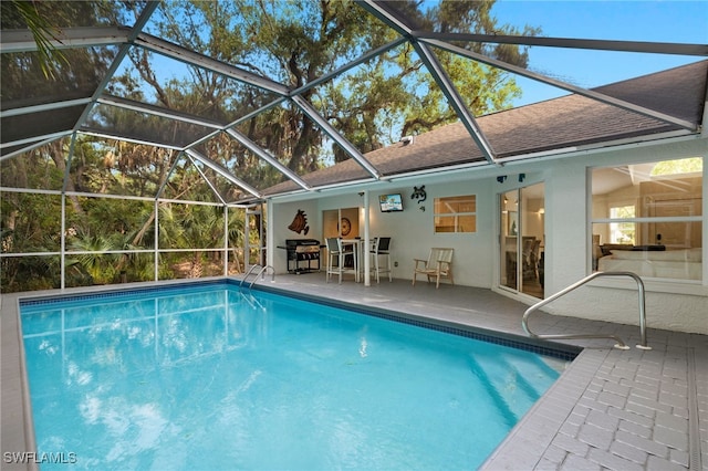 view of swimming pool with a patio area, area for grilling, and a lanai