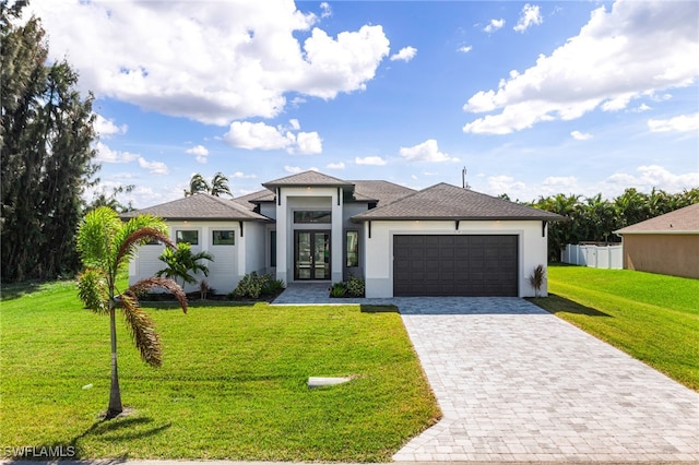 view of front of home featuring a front yard, french doors, and a garage