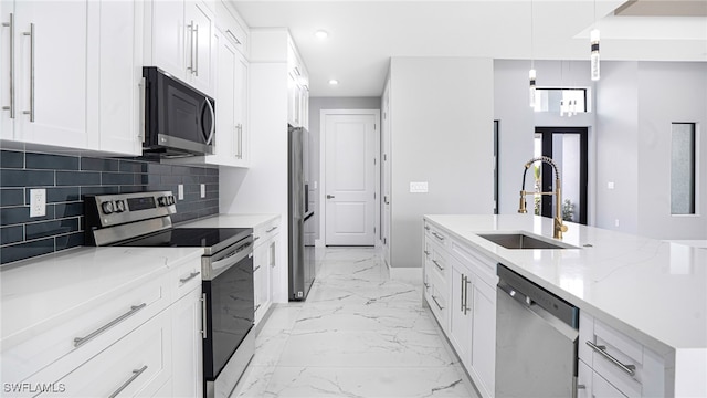 kitchen with white cabinets, appliances with stainless steel finishes, hanging light fixtures, and sink