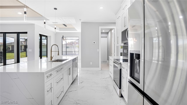 kitchen with white cabinets, decorative light fixtures, stainless steel appliances, and sink