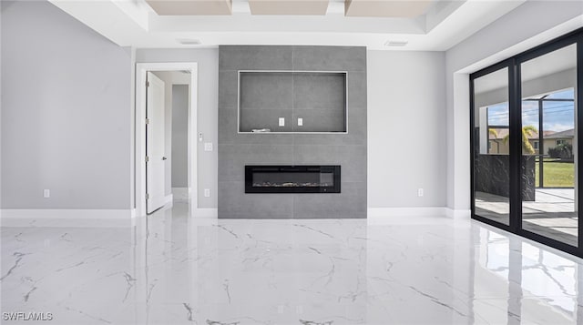 unfurnished living room featuring a raised ceiling and a tiled fireplace