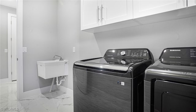 laundry room with washer and dryer, cabinets, and sink