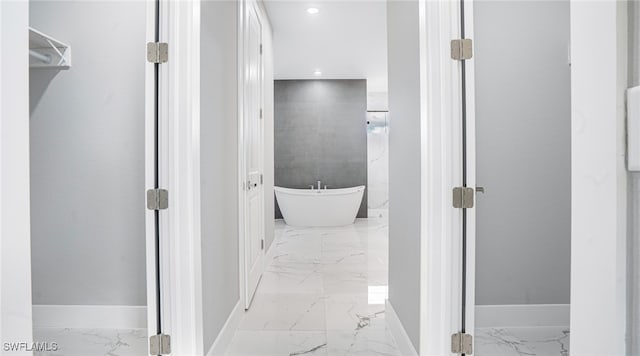 bathroom with a tub and tile walls