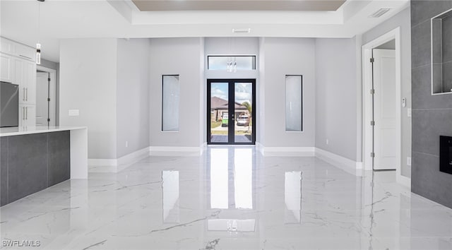 entrance foyer with a tray ceiling and french doors