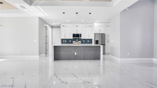 kitchen featuring white cabinets, pendant lighting, a center island with sink, and appliances with stainless steel finishes