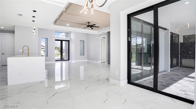 interior space featuring french doors, a tray ceiling, ceiling fan, and sink