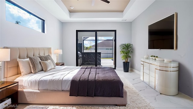 bedroom featuring a tray ceiling, access to exterior, and ceiling fan