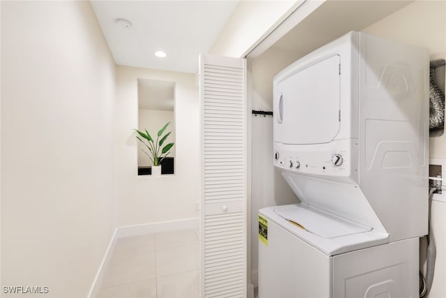 laundry area featuring light tile patterned floors and stacked washer / drying machine