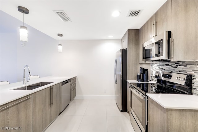 kitchen featuring sink, appliances with stainless steel finishes, tasteful backsplash, light tile patterned floors, and pendant lighting