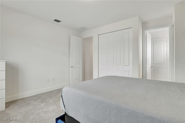 bedroom with a closet and light colored carpet