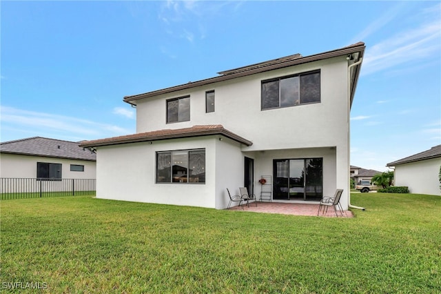 rear view of house with a patio and a lawn