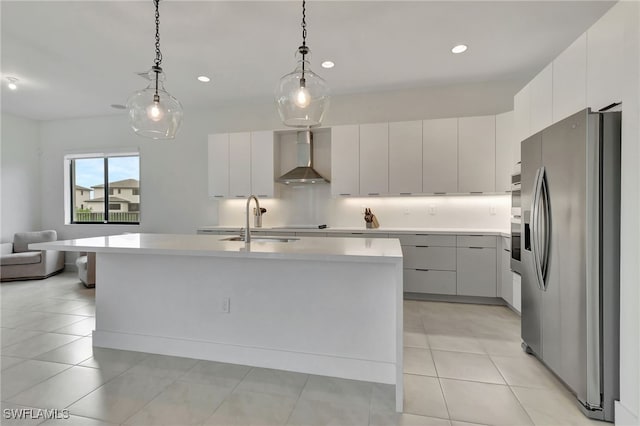 kitchen with decorative light fixtures, stainless steel appliances, and an island with sink