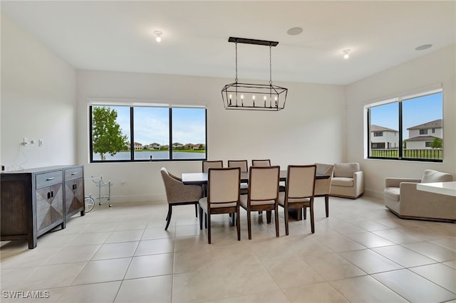 tiled dining space featuring an inviting chandelier and a healthy amount of sunlight