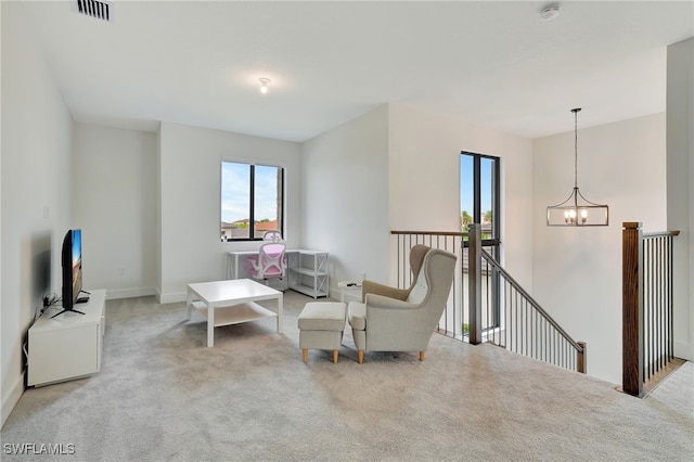 sitting room featuring light colored carpet and an inviting chandelier