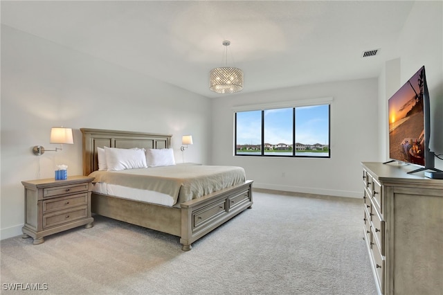 carpeted bedroom featuring a chandelier