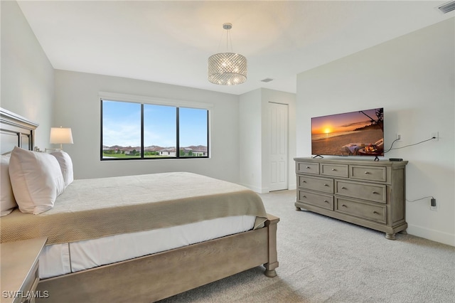 carpeted bedroom with an inviting chandelier