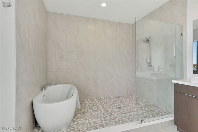 bathroom with tile walls, vanity, separate shower and tub, and tile patterned floors