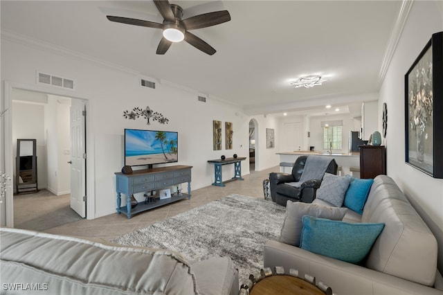 tiled living room with ceiling fan and ornamental molding