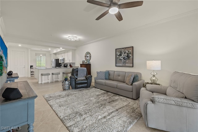 living room with crown molding, light tile patterned floors, and ceiling fan