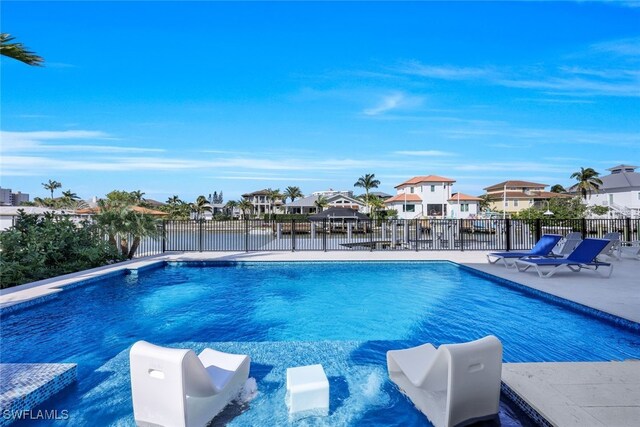 view of swimming pool featuring a water view and a patio