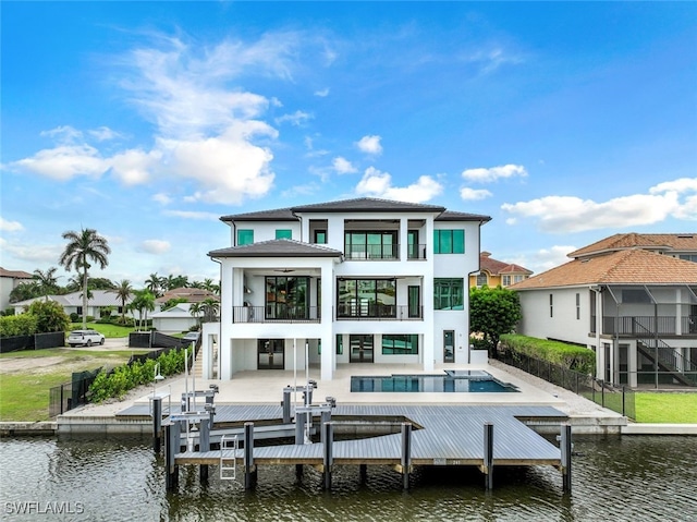 rear view of property featuring a water view, a balcony, and a patio