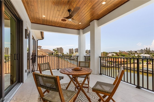 balcony with ceiling fan and a water view