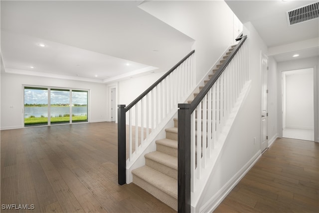 stairway featuring hardwood / wood-style floors and a tray ceiling