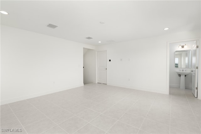 spare room featuring sink and light tile patterned floors