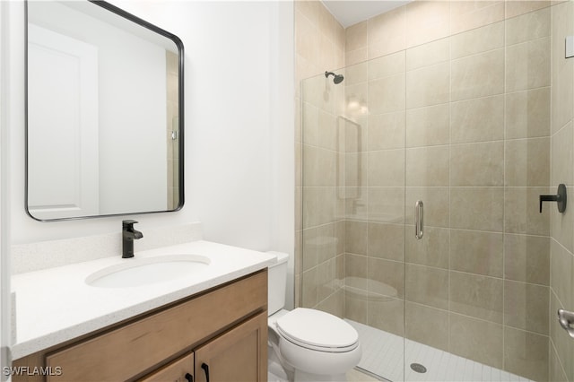 bathroom featuring toilet, a shower with shower door, and vanity