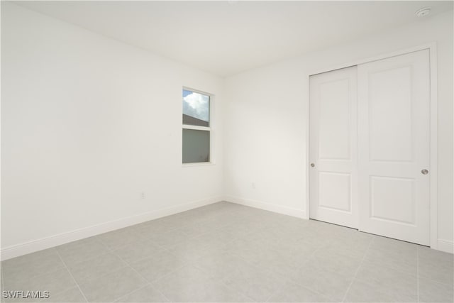 unfurnished bedroom featuring light tile patterned flooring and a closet