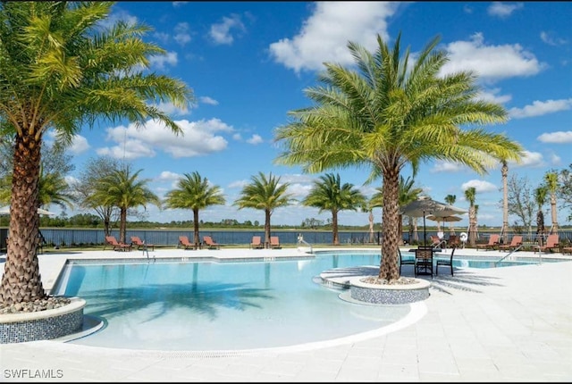 view of pool with a patio and a water view