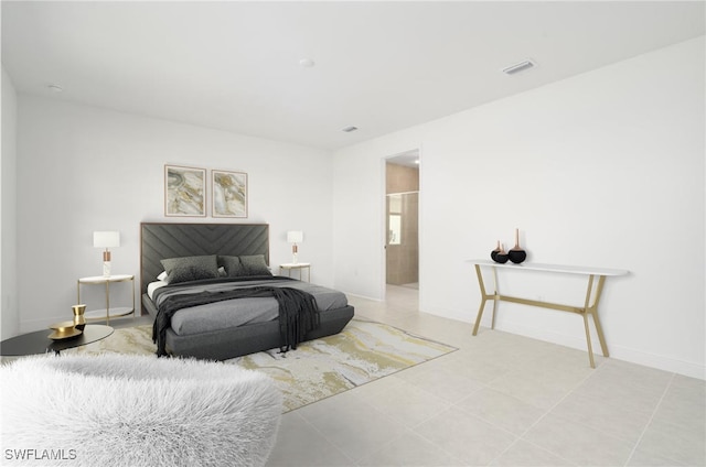 tiled bedroom featuring ensuite bath