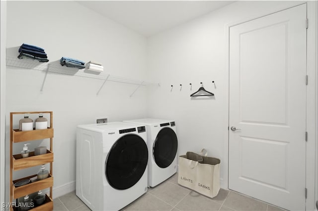 clothes washing area featuring independent washer and dryer and light tile patterned floors