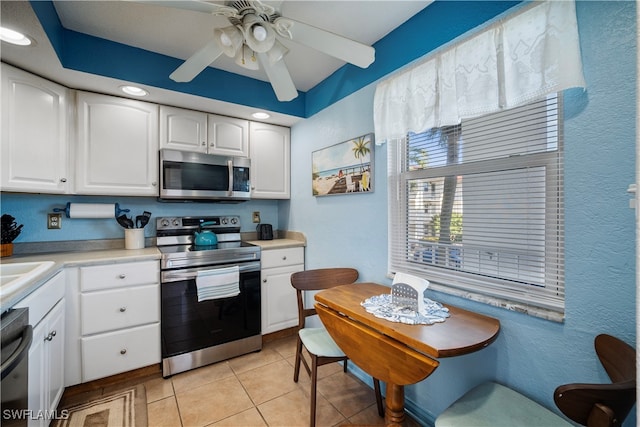 kitchen with white cabinets, ceiling fan, stainless steel appliances, and light tile patterned flooring