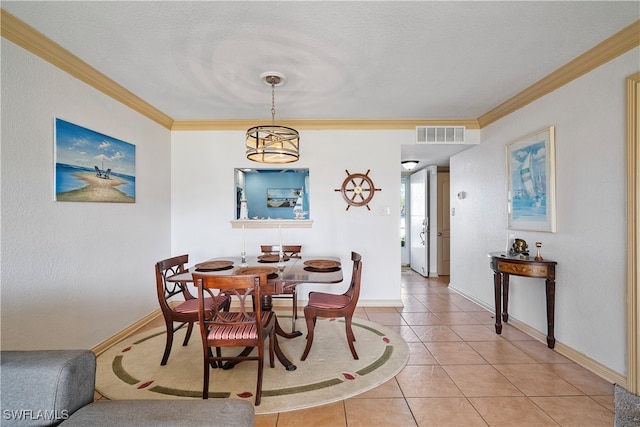 dining area with tile patterned floors, crown molding, and a textured ceiling