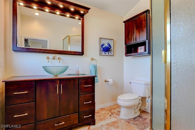 bathroom featuring vanity, vaulted ceiling, toilet, and walk in shower