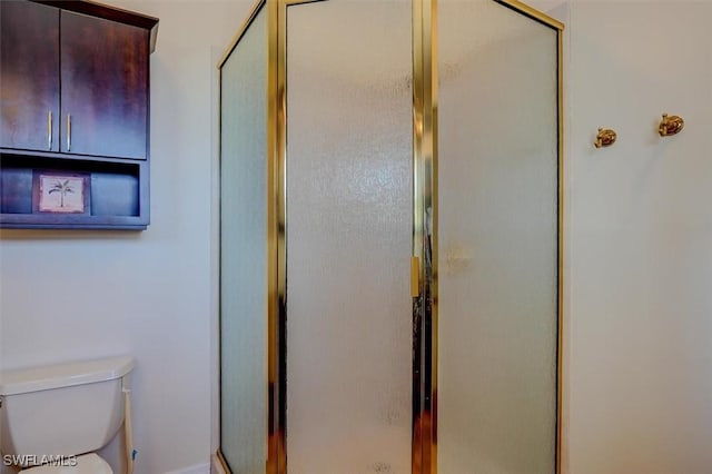 bathroom with toilet and an enclosed shower