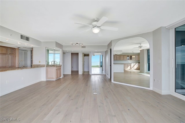 unfurnished living room featuring light hardwood / wood-style floors and sink