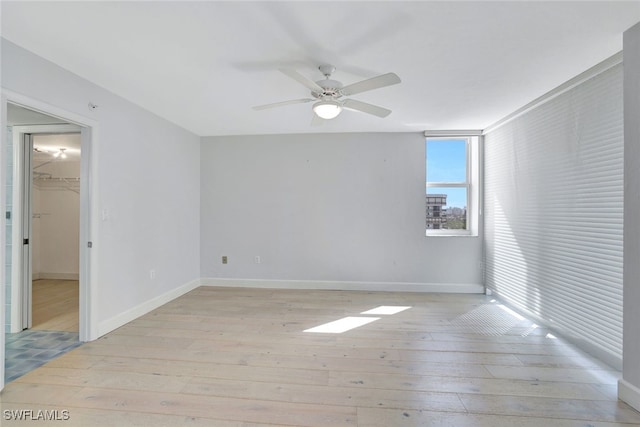 empty room featuring light wood-type flooring and ceiling fan