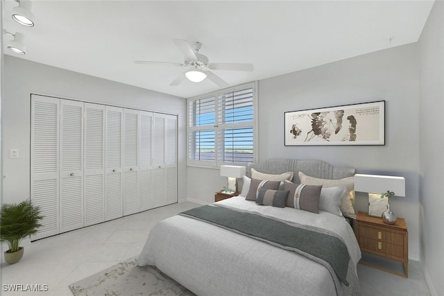 bedroom with a closet, light tile patterned flooring, and ceiling fan