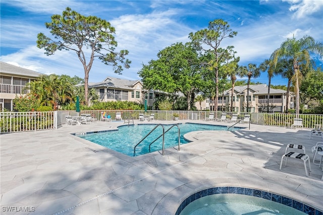 view of swimming pool featuring a community hot tub and a patio