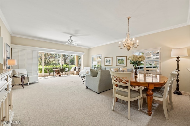 carpeted dining space featuring ceiling fan with notable chandelier, a healthy amount of sunlight, and ornamental molding