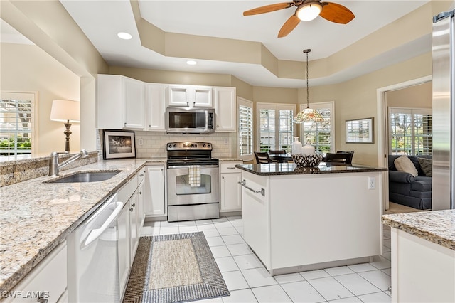 kitchen featuring stainless steel appliances, white cabinetry, a healthy amount of sunlight, and sink